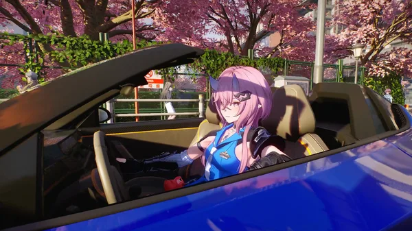 Richie driving with the car roof open beneath pink flowering trees.