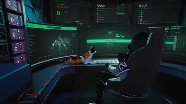 The masked Seymour seated in front of several computer screens.